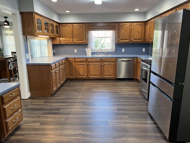 Kitchen with sink, dark wood-type flooring, applia