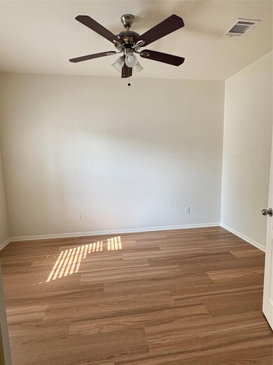 Empty room with a ceiling fan, wood finished floo