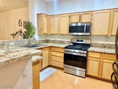 Kitchen with stainless steel appliances, light woo