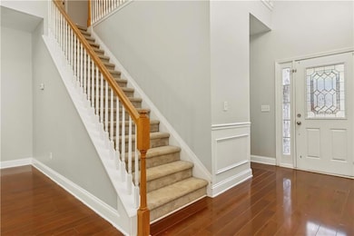 Foyer with baseboards, wood finished floors, a tow