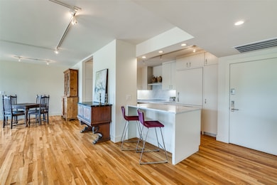 Kitchen with rail lighting, backsplash, light wood-style floors, a kitchen bar, and recessed lighting