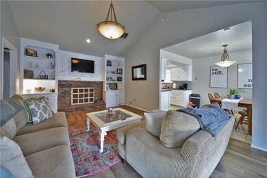 LIVING ROOM WITH BRICK FIREPLACE AND BOOK SHELVES.