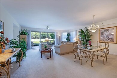 Dining room featuring light colored carpet, a chandelier, and ceiling fan