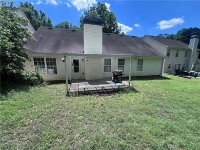 Back of property featuring a yard, a deck, and a c