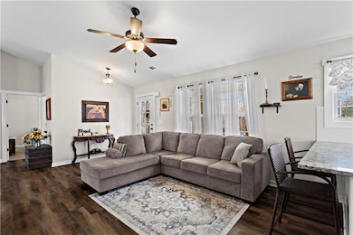 Living area with lofted ceiling, ceiling fan, base