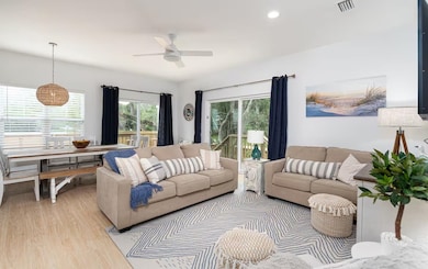 Living room with wood finished floors, healthy amount of natural light, recessed lighting, and a ceiling fan