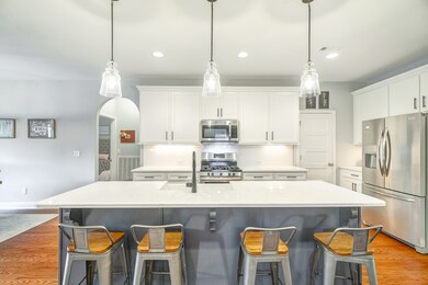Another view of the kitchen and island. Stainless steel appliances. 