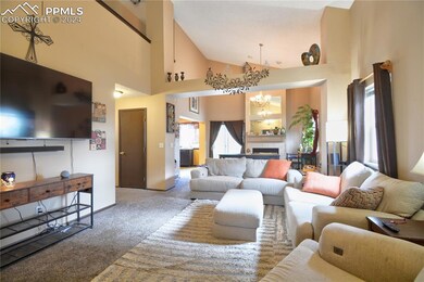 Carpeted living room featuring a tiled fireplace, 