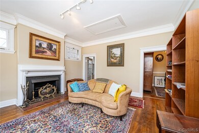 Living room featuring track lighting, dark hardwood / wood-style floors, and crown molding