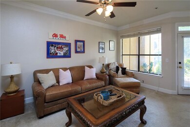 Living area with ornamental molding, ceiling fan, and carpet