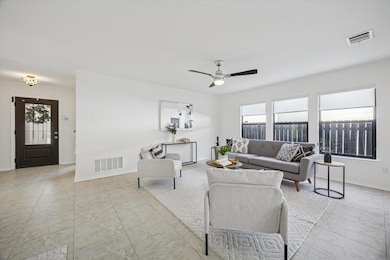 Living room with a ceiling fan and light tile pat
