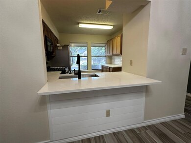 Kitchen with wood finished floors, black microwav