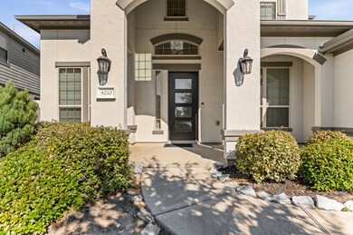 Inviting home features a modern entrance with a covered porch, and elegant lighting fixtures.