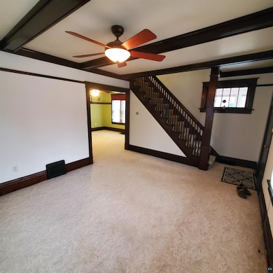 Interior space with ceiling fan, beam ceiling, and