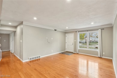 Spare room featuring light wood finished floors, recessed lighting, and crown molding