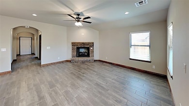 Unfurnished living room with ceiling fan, wood finished floors, arched walkways, baseboards, and recessed lighting