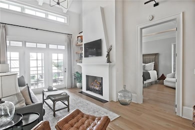 Living Room features Vaulted Ceiling and Beams with Access to Porch and Primary Bedroom