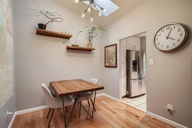 Dining area featuring a skylight and light wood f
