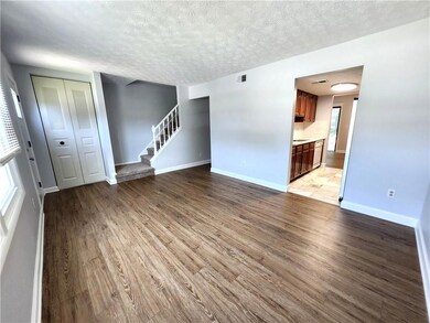Unfurnished living room featuring stairway, wood finished floors, and a textured ceiling
