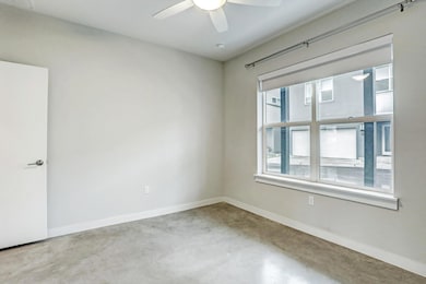 Unfurnished room featuring ceiling fan, concrete 