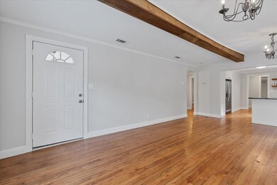 Entryway featuring beamed ceiling, light hardwood 