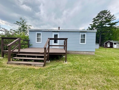 Rear view of house featuring a deck and a yard