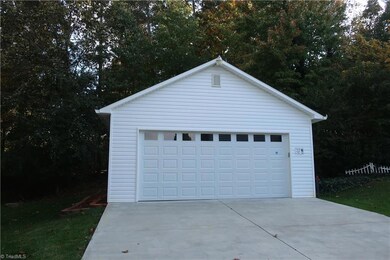 Detached oversize double garage with separate section in back for lawn equipment storage