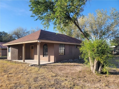View of front facade featuring stucco siding and roof with shingles