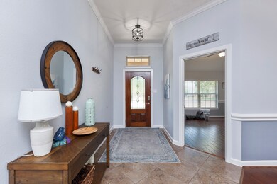 Elegant entry offering a beveled glass front door, tile floors and crown molding.