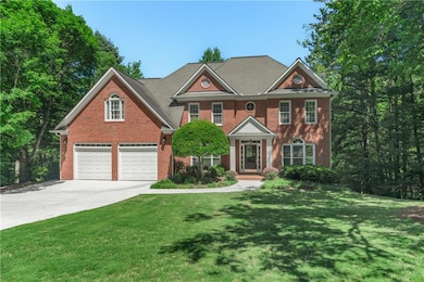 Colonial-style house with a front lawn, brick siding, a garage, and concrete driveway