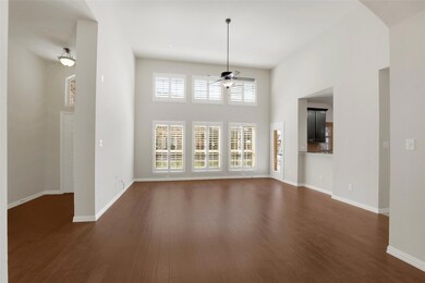 Unfurnished living room featuring baseboards, arch