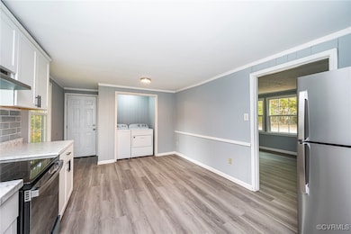 Kitchen featuring washer and clothes dryer, light