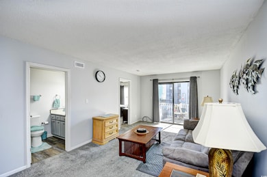 Carpeted living room with a textured ceiling and baseboards