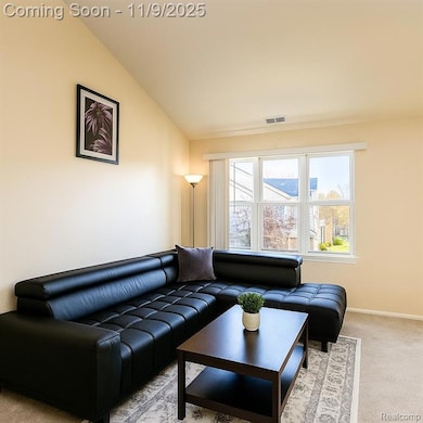 Living room with light colored carpet and lofted ceiling