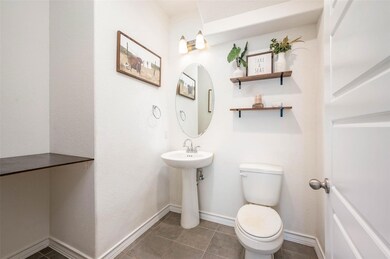 Half bathroom with toilet and tile patterned floo