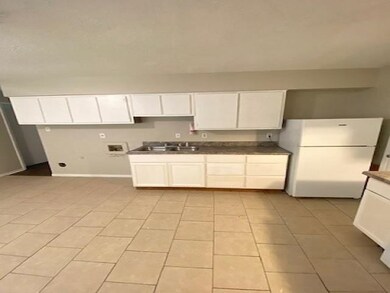 Kitchen with sink, white cabinetry, white refriger