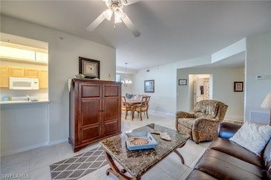 Tiled living room featuring ceiling fan with notab