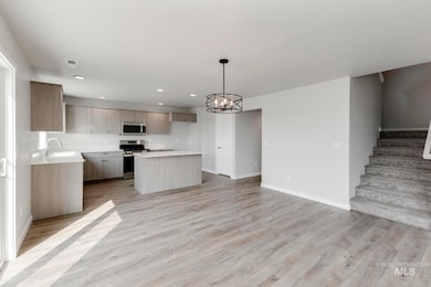 Kitchen with a kitchen island, a chandelier, open floor plan, light wood-type flooring, and recessed lighting
