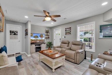 Living room with ceiling fan and light hardwood / 
