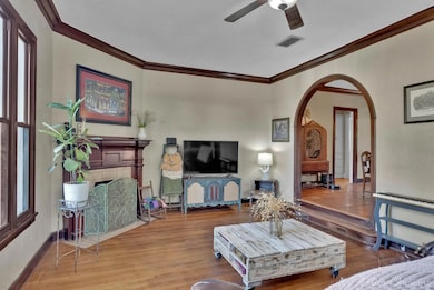 Living room with crown molding, hardwood / wood-st