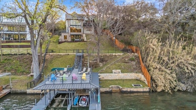 View of dock featuring a water view, fence, stair