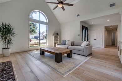 Living area with visible vents, high vaulted ceili