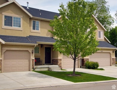 View of front of property featuring stone siding, concrete driveway, roof with shingles, stucco siding, and an attached garage