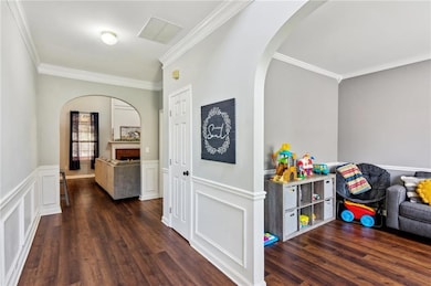 Lovely entrance features wainscotting, arched entr