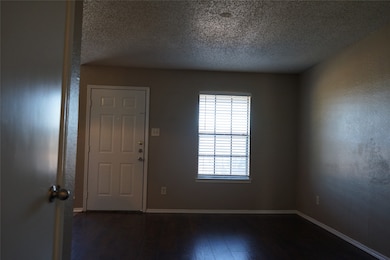 Foyer featuring a textured ceiling and dark wood-style floors