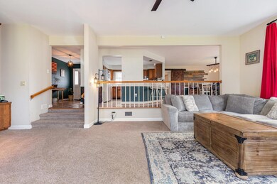 Carpeted living room featuring ceiling fan