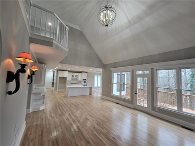 Unfurnished living room featuring high vaulted cei