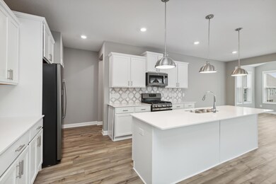 The view of the kitchen shows off the beautiful white cabinets and white quartz countertops!