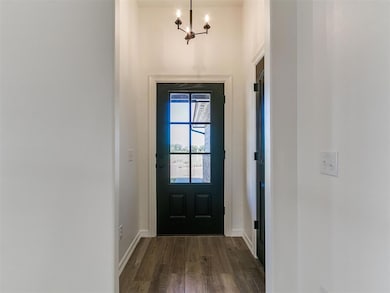 Entryway featuring dark wood-style flooring and a chandelier