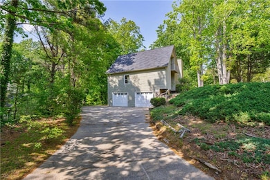 View of side of home featuring driveway, roof with